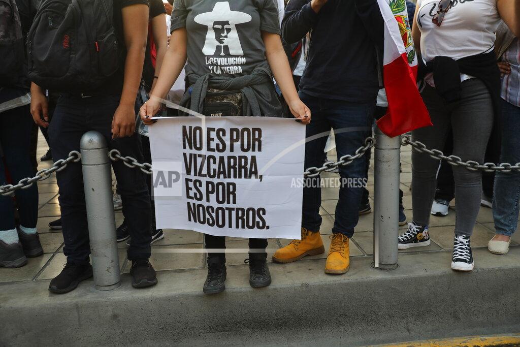 Rodrigo Abd A woman, holding a sign with a message that reads in Spanish: "It's not for Vizcarra, it's for us," joins others outside the Justice Palace where people who are refusing to recognize the new government gathered to protest, in Lima, Peru, Wednesday, Nov. 11, 2020. On Tuesday, Peru swore in Manuel Merino as president, after Peru’s legislature booted President Martin Vizcarra from office on Monday. (AP Photo/Rodrigo Abd)