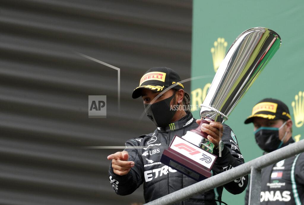 Stephanie Lecocq Mercedes driver Lewis Hamilton of Britain celebrates on the podium after winning the Formula One Grand Prix at the Spa-Francorchamps racetrack in Spa, Belgium, Sunday, Aug. 30, 2020. (Stephanie Lecocq, Pool via AP)