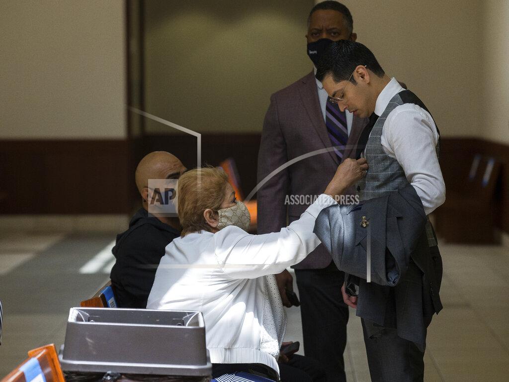Godofredo A. Vásquez Victor Hugo Cuevas, a 26-year-old linked to a missing tiger named India, gets his tie adjusted by his grandmother, who did not wish to give her name, during a lunch break in the bond revocation hearing of a separate murder charge he's facing at Fort Bend County Justice Center on Friday, May 14, 2021, in Richmond, Texas. (Godofredo A. Vásquez/Houston Chronicle via AP)