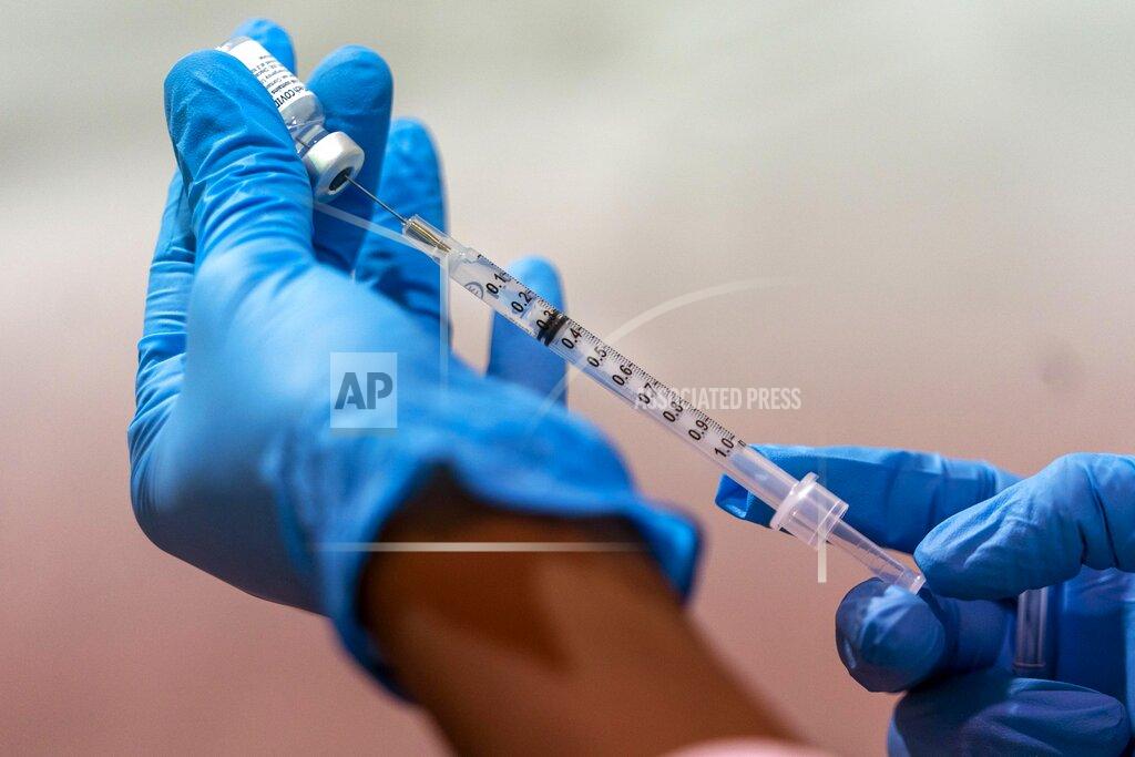Mary Altaffer FILE — In this Jan. 31, 2021, file photo, pharmacist Diana Swiga fills a dead volume syringe with the Pfizer-BioNTech COVID-19 Vaccine, at a pop-up COVID-19 vaccination site at the Bronx River Houses Community Center, in the Bronx borough of New York. States including New York are wrestling with the decision of whether to allow medically vulnerable residents below the age of 65 to receive the coronavirus vaccine. (AP Photo/Mary Altaffer, File)