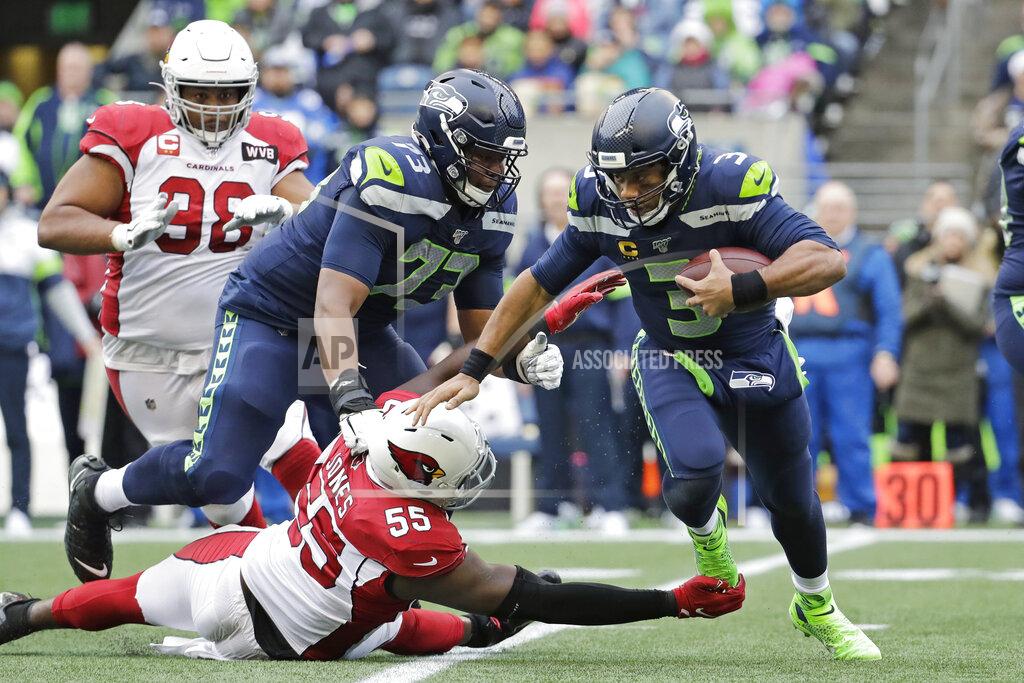 Seattle Seahawks quarterback Russell Wilson (3) is tripped up by Arizona Cardinals linebacker Chandler Jones (55) Seahawks offensive tackle Jamarco Jones (73) looks on during the first half of an NFL football game, Sunday, Dec. 22, 2019, in Seattle. (AP Photo/Lindsey Wasson)