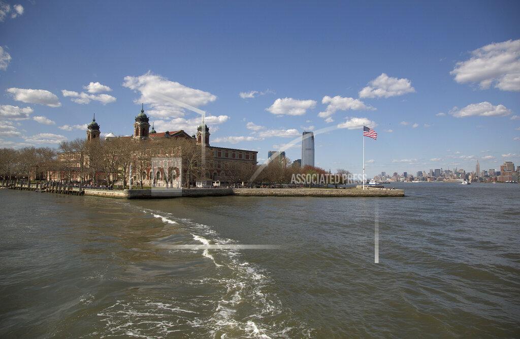 Julie Jacobson FILE - The wake from a ferry is seen trailing the boat as it leaves Ellis Island for Manhattan, on April 29, 2015, in New York. The location is featured in a collection of mini-essays by American writers published online by the Frommer's guidebook company about places they believe helped shape and define America. (AP Photo/Julie Jacobson, File)