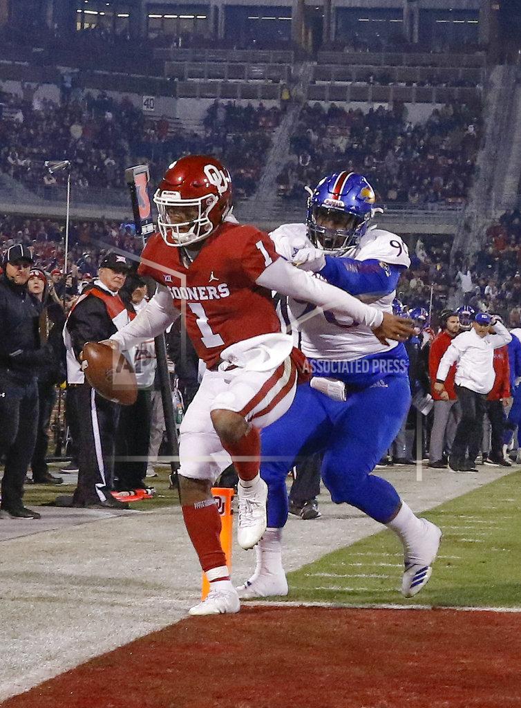 Alonzo Adams Oklahoma quarterback Kyler Murray (1) runs in for a touchdown ahead of Kansas defensive tackle Jelani Brown (90) during the second half of an NCAA college football game in Norman, Okla., Saturday, Nov. 17, 2018. Oklahoma won 55-40. (AP Photo/Alonzo Adams)