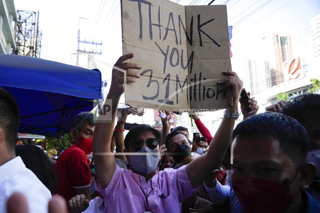 Aaron Favila Presidential candidate Ferdinand "Bongbong" Marcos Jr. holds a sign he got from the crowd as he celebrates outside his headquarters in Mandaluyong, Philippines on Wednesday, May 11, 2022. Marcos' apparent landslide victory in the Philippine presidential election is raising immediate concerns about a further erosion of democracy in Asia and could complicate American efforts to blunt growing Chinese influence and power in the Pacific. (AP Photo/Aaron Favila)