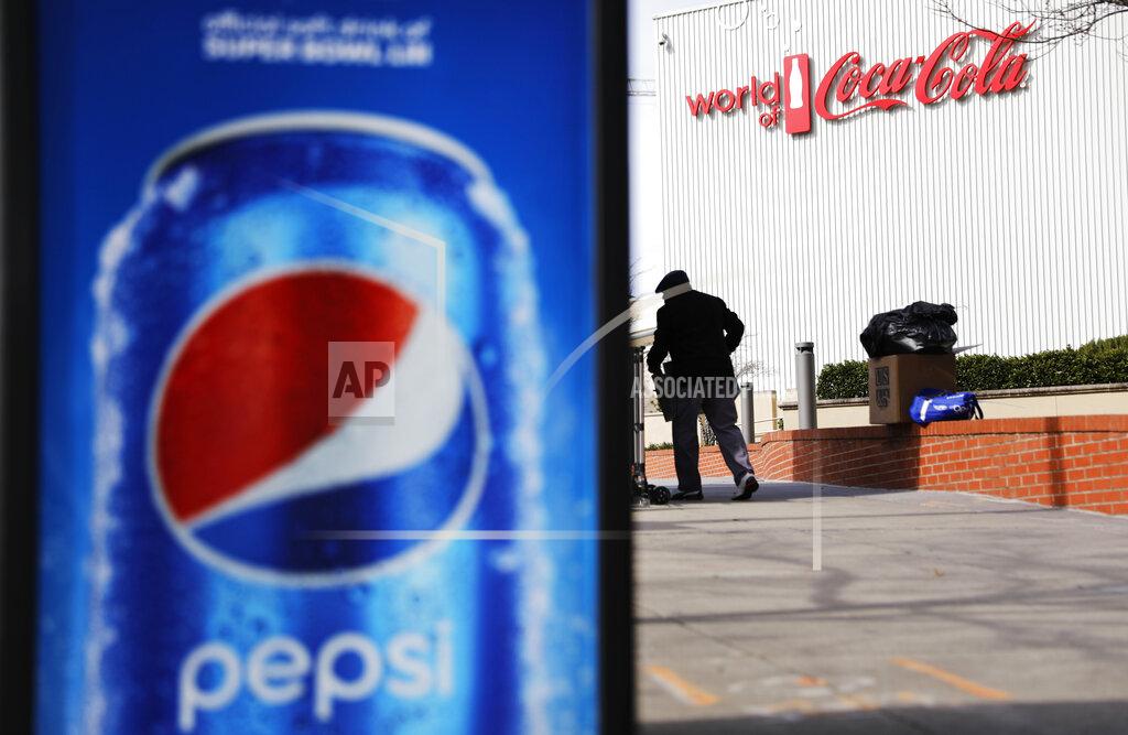 A Pepsi advertisement stands outside the World of Coca-Cola museum as a vendor stocks his kiosk in Atlanta, Wednesday, Jan. 30, 2019. The Patriots and the Rams aren't the only ones battling for Super Bowl supremacy this week. Pepsi and Coke also seem to be squaring off. Pepsi, an official NFL sponsor of Super Bowl 53, has invaded Coke's home turf, its headquarters are in Atlanta. (AP Photo/David Goldman)