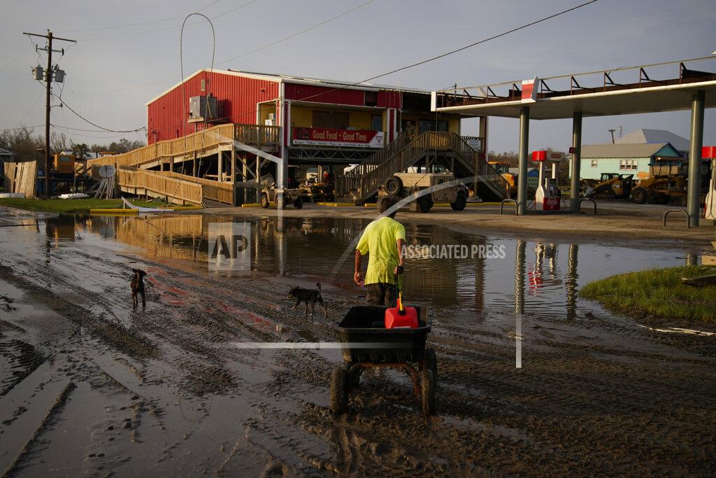John Locher A man goes for gas at a hurricane-damaged gas station in the aftermath of Ida, Monday, Sept. 6, 2021, in Grand Isle, La. (AP Photo/John Locher)