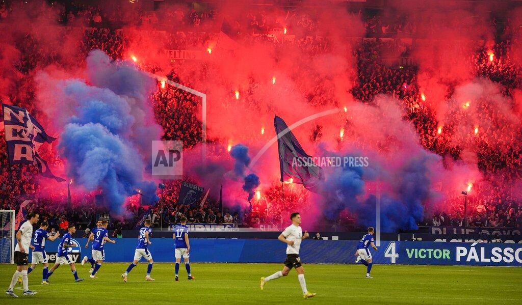 Martin Meissner Schalke supporters burn fireworks prior the 2nd Bundesliga soccer match between FC Schalke 04 and FC St. Pauli at the Arena in Gelsenkirchen, Germany, Saturday, May 7, 2022. (AP Photo/Martin Meissner)