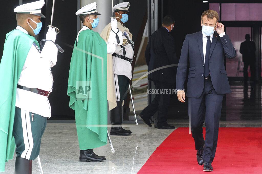 Ludovic Marin French President Emmanuel Macron, right, wears a face mask as he walks past a guard of honor upon arrival at Nouakchott Oumtounsy International Airport Tuesday June 30, 2020, in Nouakchott, to attend a G5 Sahel summit. Leaders from the five countries of West Africa's Sahel region, Burkina Faso, Chad, Mali, Mauritania and Niger, meet with French President Emmanuel Macron and Spanish Prime Minister Pedro Sanchez in Mauritania's capital Nouakchott on Tuesday to discuss military operations against Islamic extremists in the region, as jihadist attacks mount. The five African countries, known as the G5, have formed a joint military force that is working with France, which has thousands of troops to battle the extremists in the Sahel, the region south of the Sahara Desert. (Ludovic Marin, Pool via AP)