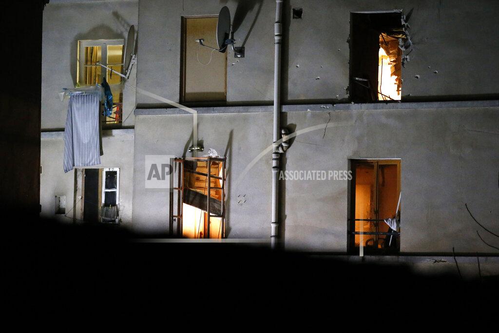 Michel Euler FILE - In this Nov. 18, 2015 file photo bullet holes and smashed windows are pictured on the back side of the house after an intervention of security forces against a group of extremists in Saint-Denis, near Paris. (AP Photo/Michel Euler, File)