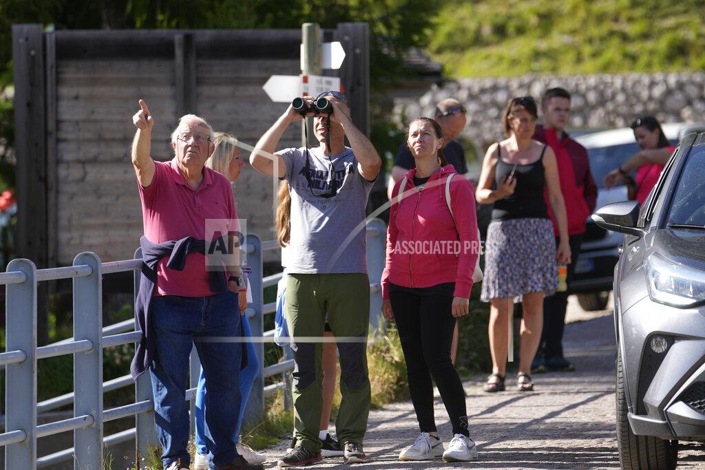 Luca Bruno People look at the Punta Rocca glacier near Canazei, in the Italian Alps in northern Italy, Monday, July 4, 2022, a day after a huge chunk of the glacier broke loose, sending an avalanche of ice, snow, and rocks onto hikers. Rescuers said conditions downslope from the glacier, which has been melting for decades, were still too unstable to immediately send rescuers and dogs into the area to look for others buried under tons of debris. (AP Photo/Luca Bruno)