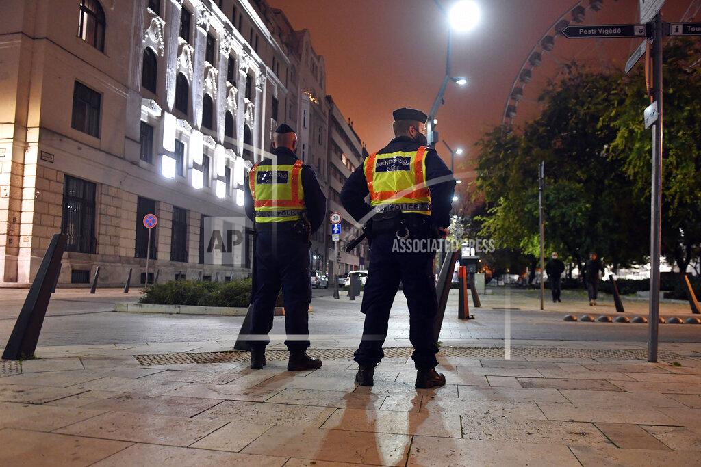Zoltan Mathe Police officers control the traffic in downtown Budapest during the curfew of the state of emergency as part of the containment measures of Covid-19 in Budapest, Hungary, late Wednesday, Nov. 11, 2020. The restrictions include a curfew between 8 p.m and 5 a.m. further the closure of restaurants, bars as well as recreational and cultural facilities, among them gyms. (Zoltan Mathe/MTI via AP)