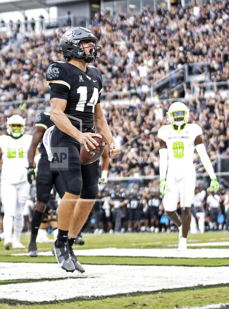 Willie J. Allen Jr. UCF quarterback Parker Navarro (14) celebrates his touchdown during an NCAA college football game against South Florida, Friday, Nov. 26, 2021, in Orlando, Fla. (Willie J. Allen Jr./Orlando Sentinel via AP)