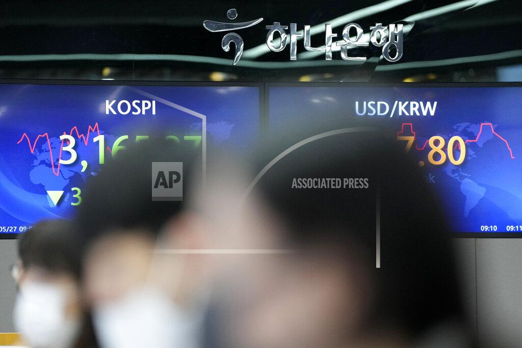 Lee Jin-Man Currency traders watch computer monitors near the screens showing the Korea Composite Stock Price Index (KOSPI), left, and the foreign exchange rate between U.S. dollar and South Korean won at the foreign exchange dealing room in Seoul, South Korea, Thursday, May 27, 2021. Asian shares fell Thursday, as investors watched for signs of inflation and awaited U.S. economic data expected later in the day. (AP Photo/Lee Jin-man)