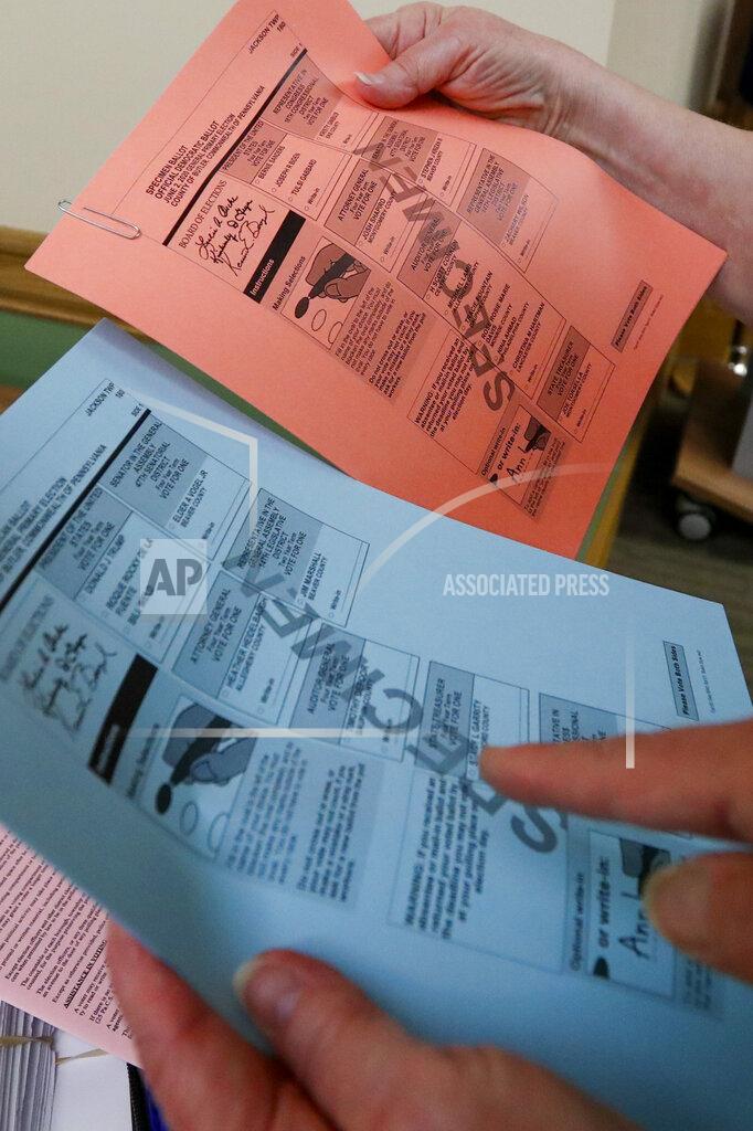 Keith Srakocic Diane White looks over some of the specimen ballots as she works to set up a polling place Monday, June 1, 2020, for the voting for Tuesday's Pennsylvania primary, in Jackson Township near Zelienople, Pa. (AP Photo/Keith Srakocic)