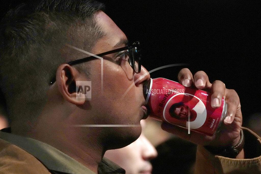 Rick Rycroft A man takes a drink of Albo branded beer at a Labor Party event following the close of the polling places in Sydney, Australia, Saturday, May 21, 2022. Also is the nickname of Labor Party Leader Anthony Albanese. Australians voted following a six-week election campaign that has focused on pandemic-fueled inflation, climate change and fears of a Chinese military outpost being established less than 1,200 miles off Australia's shore. (AP Photo/Rick Rycroft)