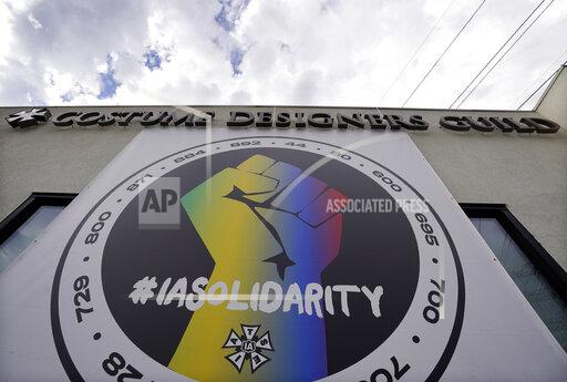 A poster advocating union solidarity hangs from a Costume Designers Guild office building, Monday, Oct. 4, 2021, in Burbank, Calif. The International Alliance of Theatrical Stage Employees (IATSE) overwhelmingly voted to authorize a strike for the first time in its 128-year history. (AP Photo/Chris Pizzello)