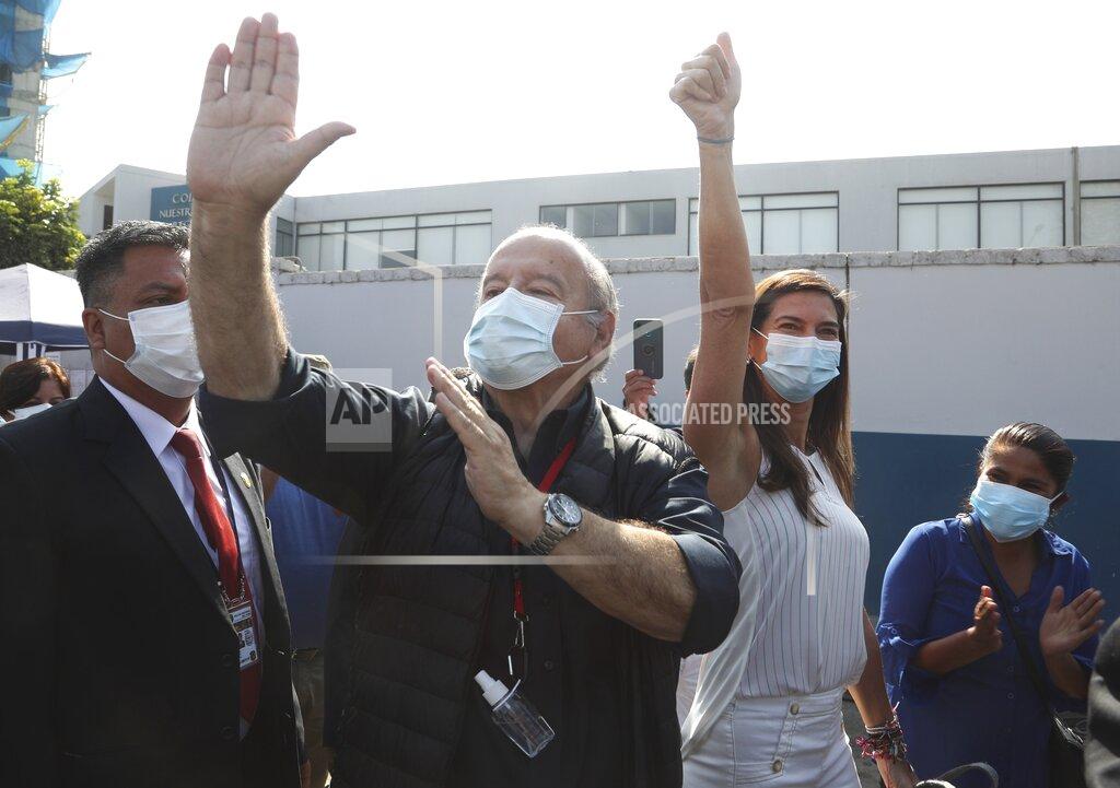 Martin Mejia Avanza Pais party presidential candidate Hernando De Soto and his wife Carla Olivieri, wave to supporters upon their arrival to vote during general elections in Lima, Peru, Sunday, April 11, 2021. (AP Photo/Martin Mejia)