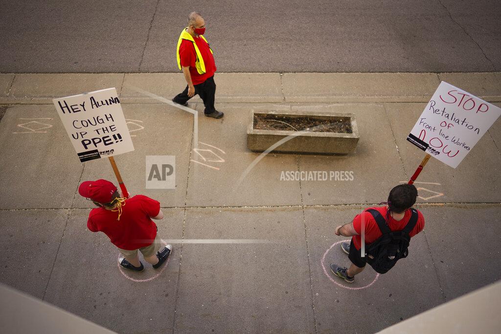 Jeff Wheeler Chalk circles on the sidewalk indicate safe social distancing for picketers, Wednesday, May 20, 2020, in St. Paul, Minn., during an informational picket sponsored by the Minnesota Nurses Association along Smith Avenue, outside United Hospital. Nurse members are asking for a say in worker protections, increased PPE resources with higher safety standards and an end to retaliation against workers who have tried to protect themselves from the COVID-19 virus. After picketing, they marched to the State Capitol to hear speakers. (Jeff Wheeler/Star Tribune via AP)