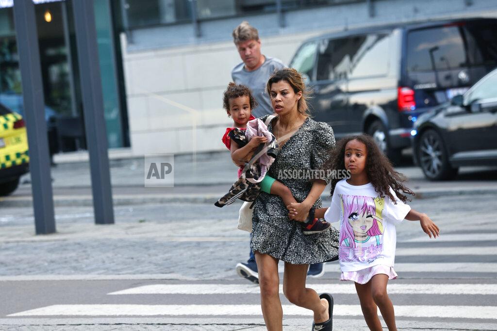 Olafur Steinar Gestsson A woman and children flee the Field's shopping center after a shooting, in Copenhagen, Denmark, Sunday, July 3, 2022. Danish police said Sunday that several people were shot at a Copenhagen shopping mall, one of the largest in Scandinavia. Copenhagen police said that one person has been arrested in connection with the shooting at the Field’s shopping mall, which is close to the city's airport. Police tweeted that “several people have been hit,” but gave no other details. (Olafur Steinar Gestsson/Ritzau Scanpix via AP)