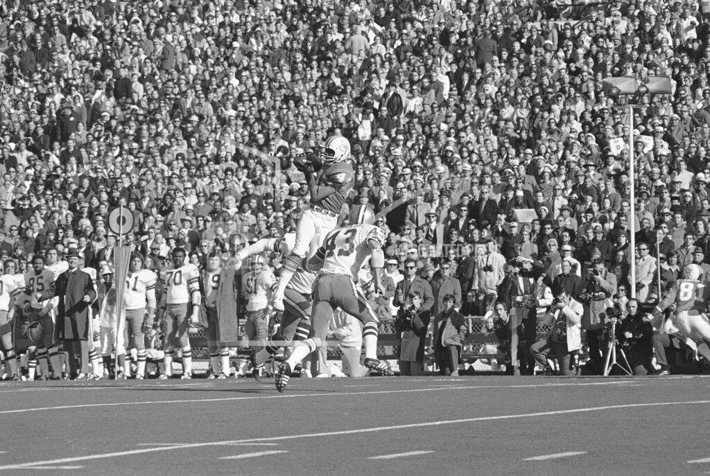 Uncredited FILE - Miami Dolphins receiver Paul Warfield goes high in the air as he hauls in a pass from quarterback Bob Griese during the Super Bowl game against the Dallas Cowboys in New Orleans, in this Jan. 16, 1972, file photo. Trying to defend is Dallas' Cliff Harris (43). Warfield already had an NFL championship with the Cleveland Browns when they traded him to Miami for the No. 3 overall pick in the 1970 draft. That deal helped turn the Dolphins from losers to champions, though it took two years for Miami to reach its first Super Bowl. (AP Photo/File)