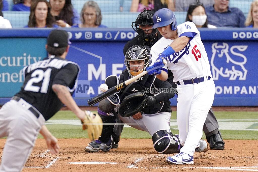 Mark J. Terrill Los Angeles Dodgers' Austin Barnes, right, hits a solo home run as Colorado Rockies starting pitcher Kyle Freeland, left, watches along with catcher Dom Nunez, second from left, and home plate umpire Vic Carapazza during the second inning of a baseball game Saturday, July 24, 2021, in Los Angeles. (AP Photo/Mark J. Terrill)