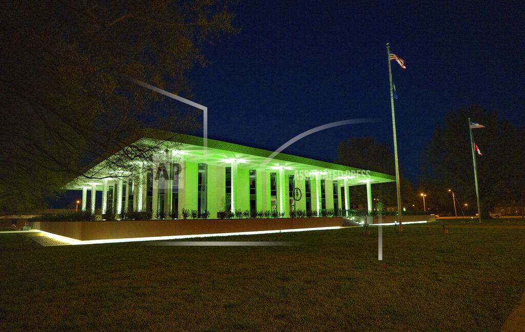 This photo taken March 31, 2020, shows Paducah's City Hall being illuminated by green lights as a sign of solidarity to the seven lives lost in Kentucky as the COVID-19 pandemic continues. Homes and businesses throughout Paducah match City Hall's sentiment with their own green lights shining. (Thomas Dean Stewart/The Paducah Sun via AP)