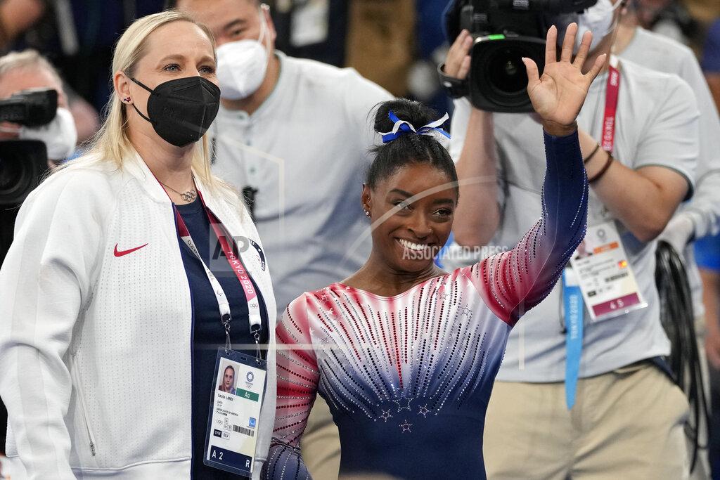 Ashley Landis Simone Biles, of the United States, waves standing next to her coach Cecile Landi after performing on the balance beam during the artistic gymnastics women's apparatus final at the 2020 Summer Olympics, Tuesday, Aug. 3, 2021, in Tokyo, Japan. (AP Photo/Ashley Landis)