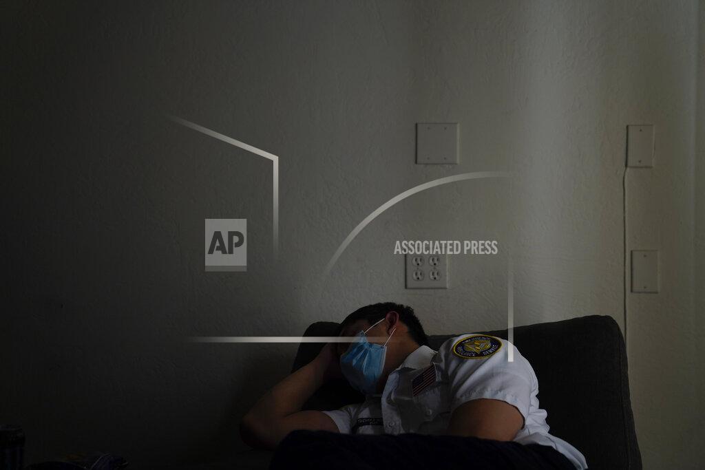 Jae C. Hong Emergency medical technician Thomas Hoang, 29, of Emergency Ambulance Service, falls asleep in a recliner while on standby for a dispatch call in Placentia, Calif., Saturday, Jan. 9, 2021. (AP Photo/Jae C. Hong)