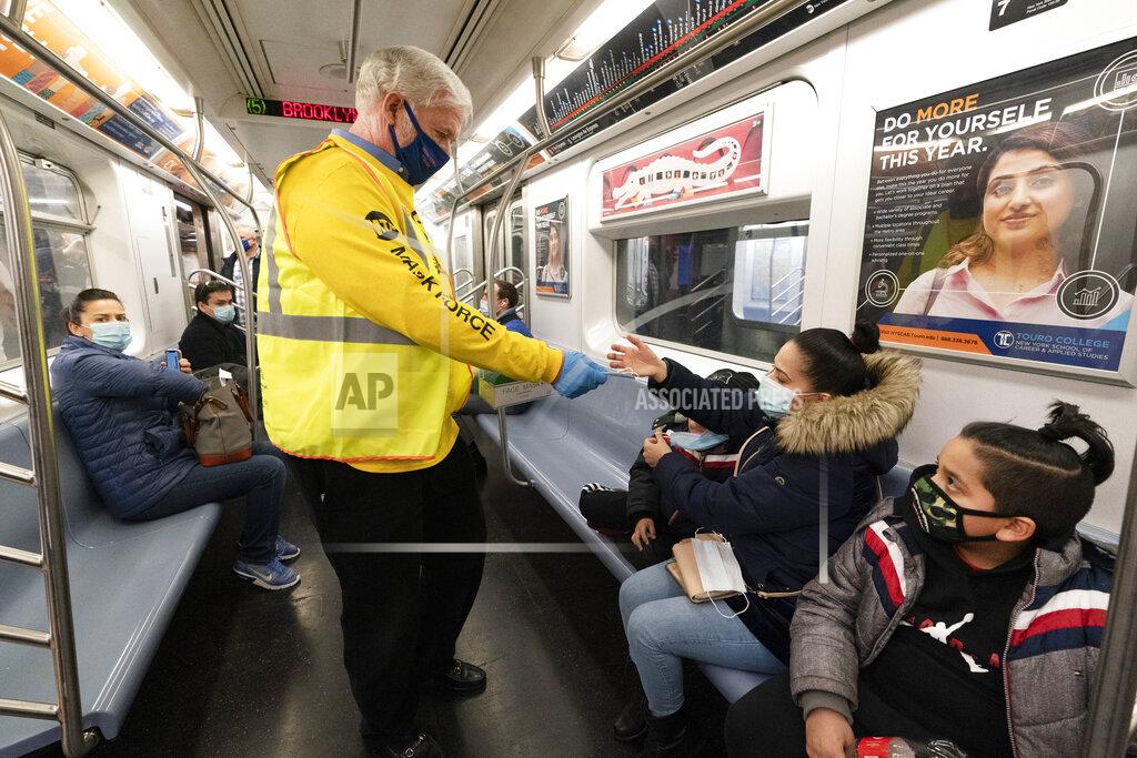 Mark Lennihan FILE - In this Tuesday, Nov. 17, 2020, file photo, Patrick Foye, Chairman and CEO of the Metropolitan Transportation Authority, hands out face masks on a New York City subway. For the New York area’s public transit providers, 2020 was a year of existential challenges created by the coronavirus pandemic. Ridership and revenues cratered, more than 100 transit employees lost their lives and gaping budget holes could remain problematic for years. (AP Photo/Mark Lennihan, File)