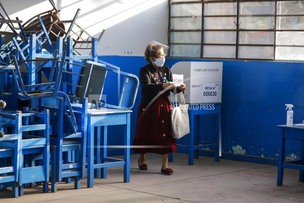 Guadalupe Pardo A woman wearing a mask to curb the spread of the new coronavirus carries her marked ballot during general elections at the Villa El Salvador neighborhood in Lima, Peru, Sunday, April 11, 2021. (AP Photo/Guadalupe Pardo)