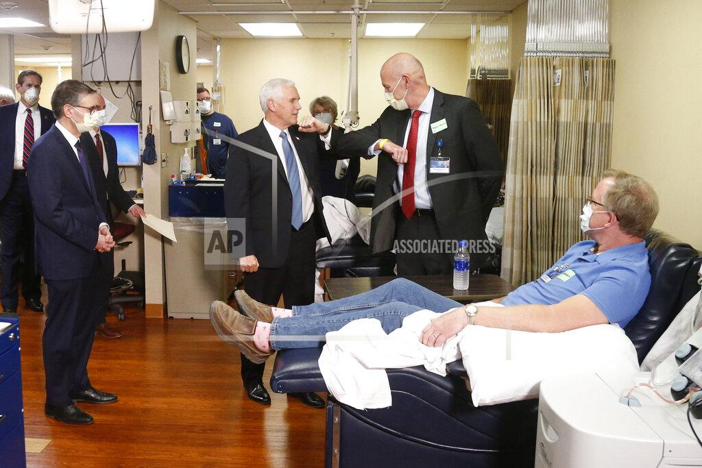 Jim Mone Vice President Mike Pence, center, elbow bumps, Dr. Michael Joiner as Dennis Nelson, right, who survived the coronavirus, listens during Pence's visit to the Mayo Clinic Tuesday, April 28, 2020, in Rochester, Minn., where he toured the facilities supporting COVID-19 research and treatment. Pence chose not to wear a face mask while touring the Mayo Clinic in Minnesota. It's an apparent violation of the world-renowned medical center's policy requiring them. (AP Photo/Jim Mone)