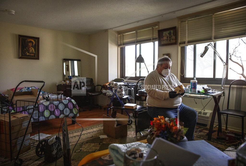 David Goldman Michael Tokar packs up the apartment of his father, David Tokar, after he died from complications from coronavirus, in the Brooklyn borough of New York, Sunday, April 12, 2020. "I miss him. I like to call him sometimes. Ask him what you need, what you want, sometimes just to keep him busy," said Tokar of his 92-year-old father who collected stamps and liked to go to the casino. "I know he was old man and I was prepared that one day he'd pass away. But I wasn't ready for this. I'm not ready now." (AP Photo/David Goldman)