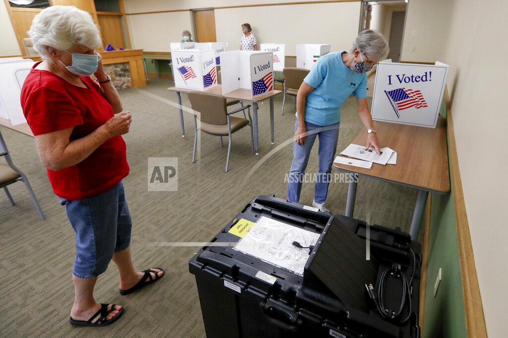 Keith Srakocic Kay Thiebaud, left, and Lynn Meyers check procedure as they start to set up one of the scanners used in tabulating the vote as they start to set up their polling place Monday, June 1, 2020, for the voting for Tuesday's Pennsylvania primary, in Jackson Township near Zelienople, Pa. (AP Photo/Keith Srakocic)