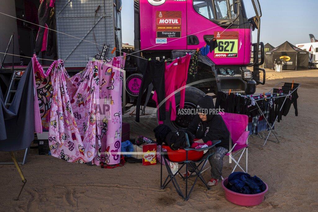 Bernat Armangue In this Monday, Jan. 13, 2020 photo, a team member of driver Camelia Liparoti, of Italy, and co-driver Annett Fischer, of Germany, does the laundry after stage eight of the Dakar Rally in Wadi Al Dawasir, Saudi Arabia. Formerly known as the Paris-Dakar Rally, the race was created by Thierry Sabine after he got lost in the Libyan desert in 1977. Until 2008, the rallies raced across Africa, but threats in Mauritania led organizers to cancel that year's event and move it to South America. It has now shifted to Saudi Arabia. The race started on Jan. 5 with 560 drivers and co-drivers, some on motorbikes, others in cars or in trucks. Only 41 are taking part in the Original category. (AP Photo/Bernat Armangue)