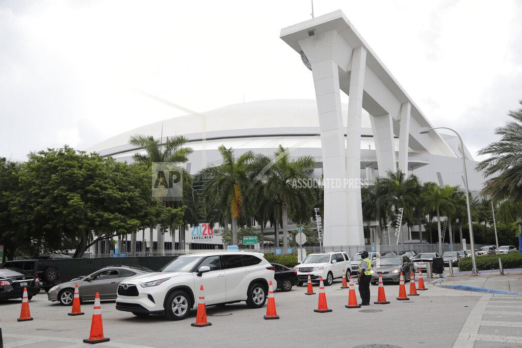 Lynne Sladky Vehicles wait in line outside of Marlins Park at a COVID-19 testing site during the coronavirus pandemic, Monday, July 6, 2020, in Miami. The long line of cars each morning as players arrive at work provides a reminder of the risks when they leave. Behavior away from the ballpark will be a big factor in determining whether Major League Baseball's attempt to salvage the 2020 season can succeed. (AP Photo/Lynne Sladky)