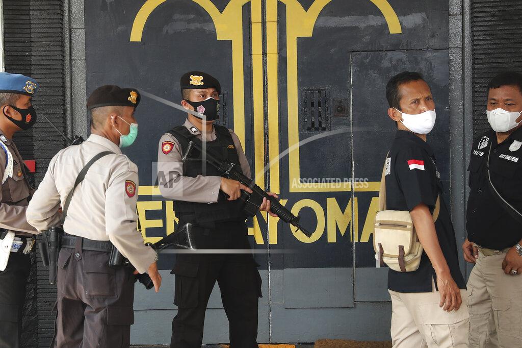 Tatan Syuflana Police officers guard at the main entrance gate of Tangerang prison in Tangerang on the outskirts of Jakarta, Indonesia, Wednesday, Sept. 8, 2021. A massive fire raged through the overcrowded prison early Wednesday, killing a number of inmates. (AP Photo/Tatan Syuflana)