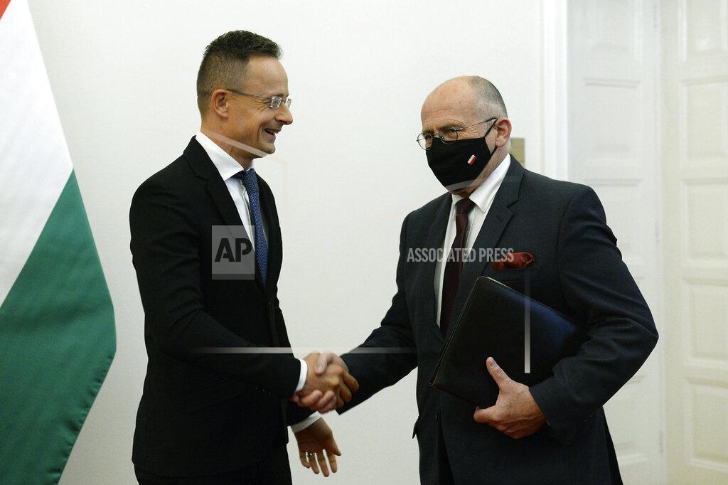 Hungarian Minister of Foreign Affairs and Trade Peter Szijjarto, left, receives his Polish counterpart, Zbigniew Rau in the Ministry of Foreign Affairs and Trade in Budapest, Hungary, Monday, Sept. 28, 2020. (Lajos Soos/MTI via AP)