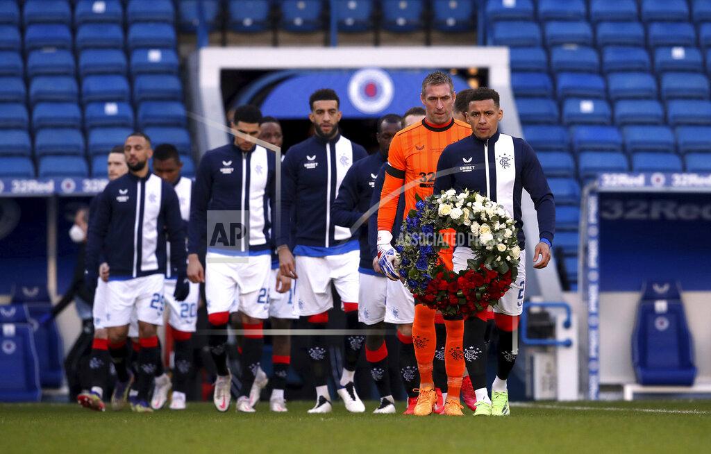 Andrew Milligan Rangers' James Tavernier carries a wreath onto the pitch on the 50th anniversary of the Ibrox disaster ahead of the Scottish Premiership match between Rangers and Celtic at Ibrox Stadium, Glasgow, Saturday Jan. 2, 2021. The anniversary marks 50 years since the disaster at the stadium which claimed the lives of 66 people. The fans were crushed on a stairway when barriers collapsed at the Glasgow venue. (Andrew Milligan/PA via AP)