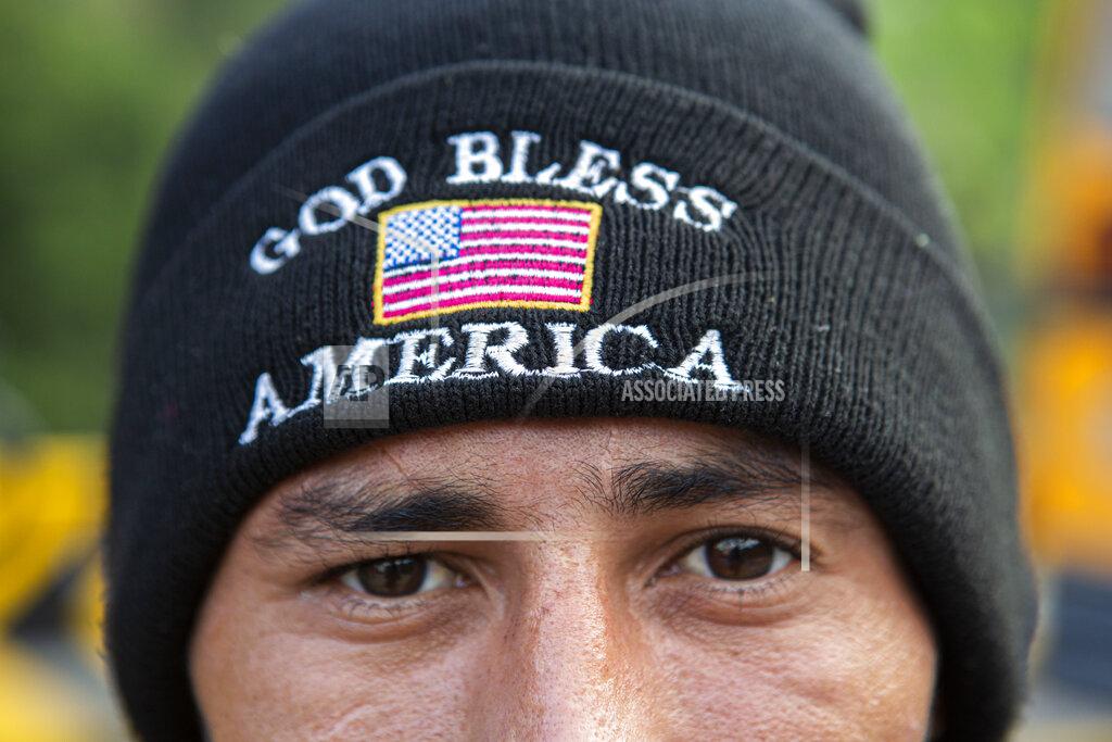 Oliver De Ros An Honduran migrant who tried to the U.S.-Mexico border eyes the camera wearing a God Bless America beanie, after he was detained and returned to his home country, in Copan, Honduras, Wednesday, Jan. 20, 2021. After a year of pandemic-induced paralysis, those in daily contact with migrants believe the flow north could return to the high levels seen in late 2018 and early 2019. (AP Photo/Oliver de Ros)