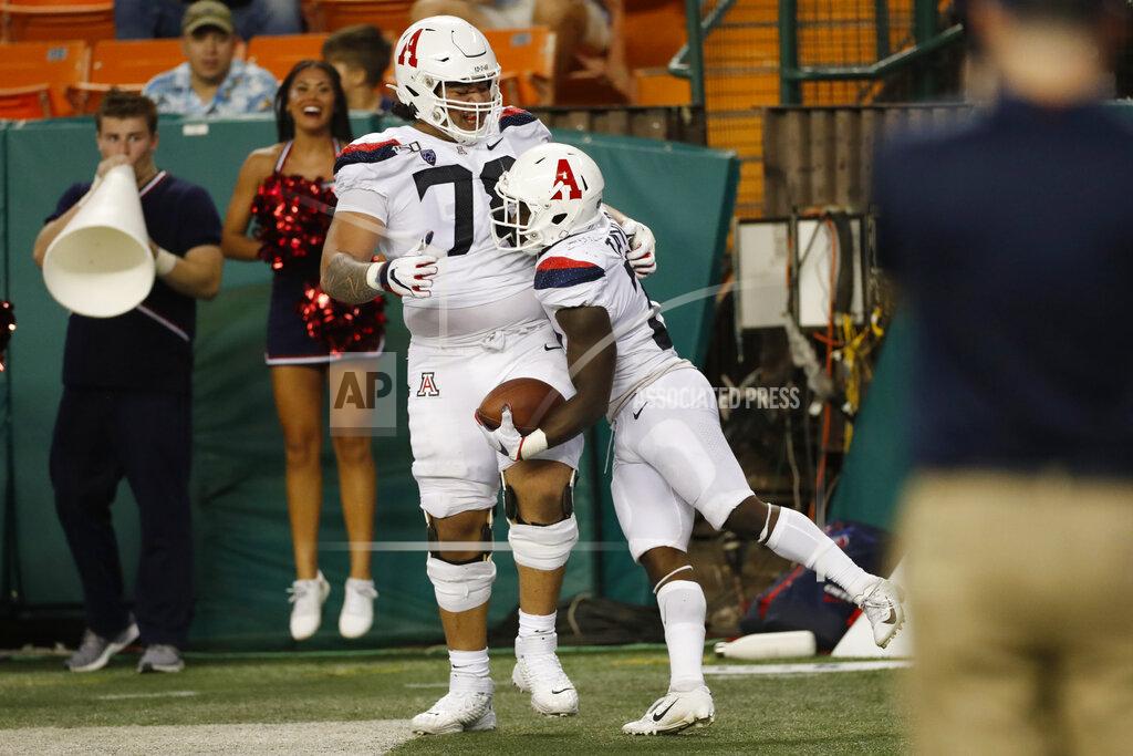 Marco Garcia After scoring a second half touchdown against Hawaii, Arizona running back J.J. Taylor (21) celebrates with offensive lineman Donovan Laie (78) during an NCAA college football game, Saturday, Aug. 24, 2019, in Honolulu. (AP Photo/Marco Garcia)