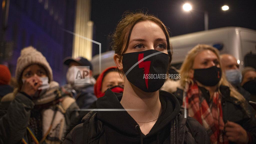 Demonstrators wear masks with the red lightning bold, a symbol of the pro-choice movement, during a protest against a top court ruling restricting abortions in Warsaw, Poland, Wednesday, Nov. 18, 2020. The upheaval began when the constitutional court, packed with loyalists of the conservative ruling party, ruled Oct. 22 to ban abortions in cases of congenital fetal defects, even if the fetus has no chance of survival. (AP Photo/Agata Grzybowska)