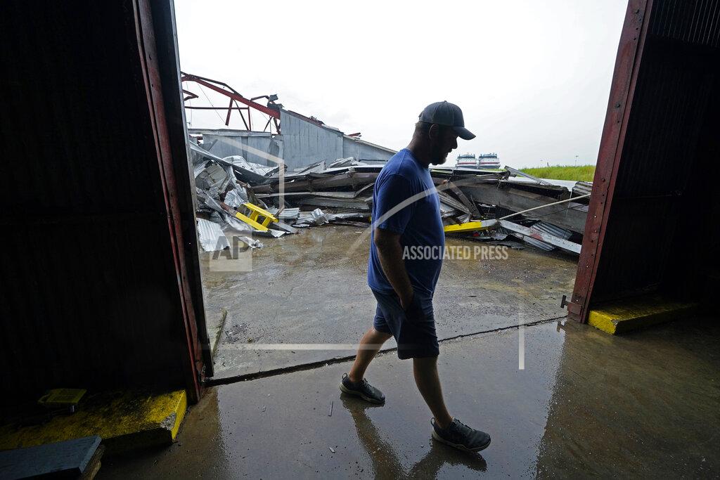 Gerald Herbert Jarod Voisin walks through damage of his family's heavily damaged oyster processing plant, as rain from Tropical Storm Nicholas, currently in the Gulf of Mexico, comes down, in the aftermath of Hurricane Ida in Houma, La., Tuesday, Sept. 14, 2021. (AP Photo/Gerald Herbert)