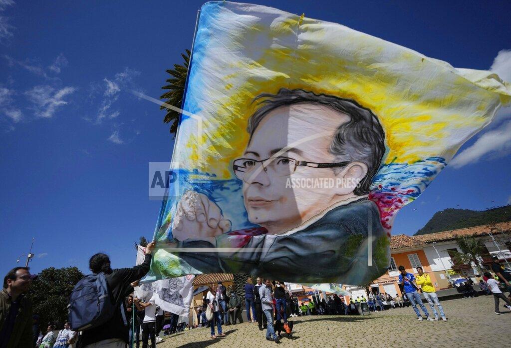 Fernando Vergara A supporter of Historical Pact coalition presidential candidate Gustavo Petro, holds a flag with the image of Petro before a closing campaign rally in Zipaquira, Colombia, Sunday, May 22, 2022. Elections are set for May 29. (AP Photo/Fernando Vergara)