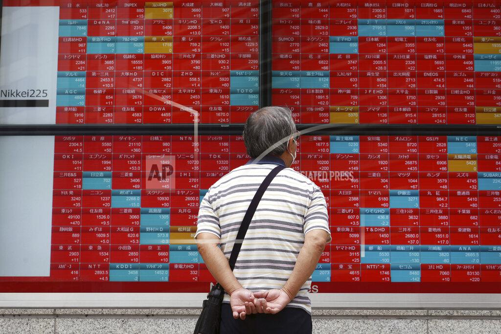 Eugene Hoshiko A man wearing a protective mask looks at an electronic stock board showing Japan's Nikkei 225 index at a securities firm Friday, June 25, 2021, in Tokyo. Asian shares are rising, buoyed by the rally on Wall Street that came after President Joe Biden announced a bipartisan deal on infrastructure spending. (AP Photo/Eugene Hoshiko)