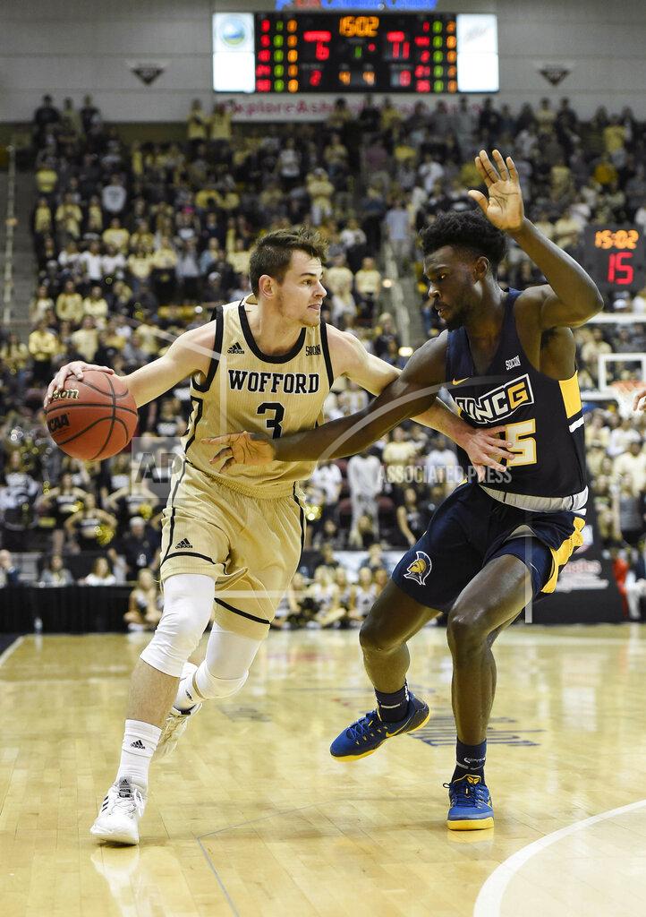 Kathy Kmonicek Wofford guard Fletcher Magee (3) tries to control the ball against UNC-Greensboro forward Khyre Thompson (15) in the first half of an NCAA college basketball game for the Southern Conference tournament championship, Monday, March 11, 2019, in Asheville, N.C. (AP Photo/Kathy Kmonicek)