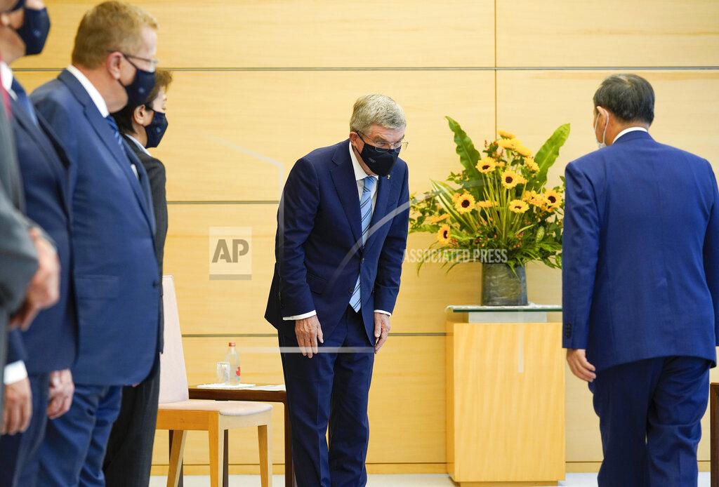 International Olympic Committee President Thomas Bach, center, bows to Japanese Prime Minister Yoshihide Suga during his courtesy call at the prime minister's official residence in Tokyo, Japan, Wednesday, July 14, 2021.(Kimimasa Mayama/Pool Photo via AP)