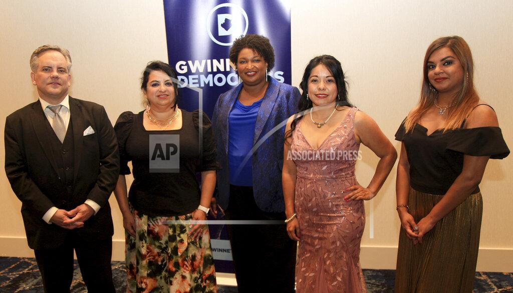 Akili-Casundria Ramsess Stacey Abrams, center, poses for a photo with the Gwinnett County Democratic Party officers at a fundraiser on Saturday, May 21, 2022, in Norcross, Ga. From left to right are Curt Johnson, Clara Puerta, Abrams, Brenda Lopez and Stephany Sheriff. (AP Photo/Akili-Casundria Ramsess)