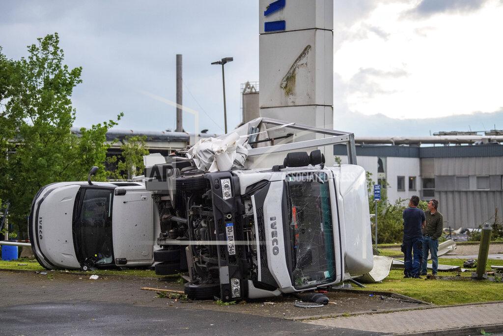 Lino Mirgeler Two trucks overturned after a storm in Paderborn, Germany, Friday, May 20, 2022. A tornado swept through the western German city of Paderborn on Friday, injuring at least 30 people as it blew away roofs, toppled trees and sent debris flying for miles, authorities said. (Lino Mirgeler/dpa via AP)