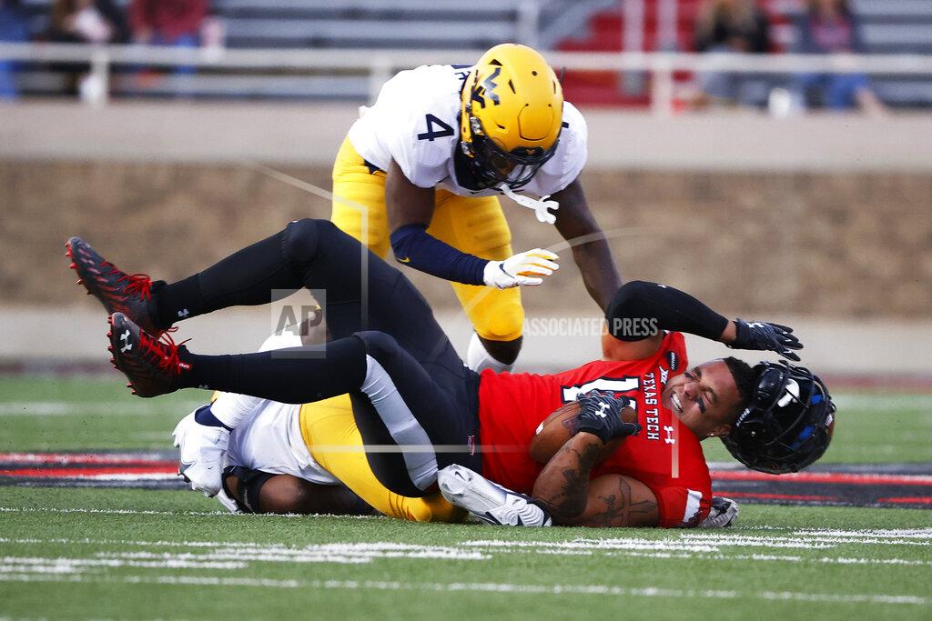 Brad Tollefson West Virginia's Josh Chandler-Semedo (7) and Alonzo Addae (4) tackle Texas Tech's Travis Koontz (15) during the second half of an NCAA college football game on Saturday, Oct. 24, 2020, in Lubbock, Texas. (AP Photo/Brad Tollefson)