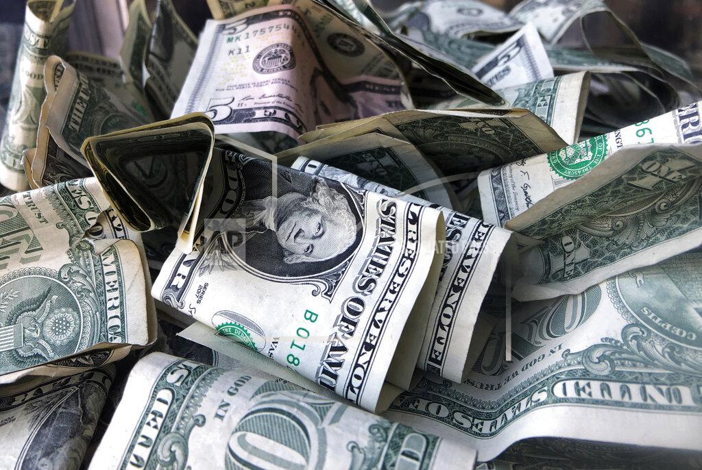 FILE - This Wednesday, April 3, 2019, file photo shows a box filled with dollar bills, in New York. Money is a huge source of stress for many people and more stress is the last thing anyone needs during a global pandemic. It can be easy to avoid checking your finances and dealing with issues, but that avoidance tends to backfire. (AP Photo/Mark Lennihan, File)